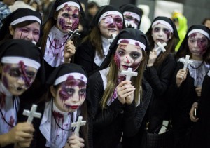 Women dressed as nuns pose for pictures during Halloween celebrations in the Shibuya district in Tokyo on October 31, 2015