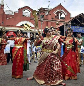 Women dressed up as Goddess Durga perform at a market for the upcoming Durga Puja festival in Kolkata on September 20, 2016.