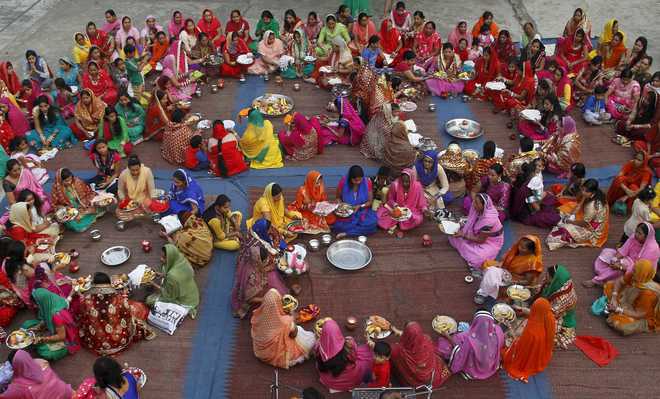 Women pray during Karwa Chauth, a traditional Hindu festival celebrated in northern India during which married women fast one whole day and offer prayers to the moon for the welfare, prosperity, and longevity of their husbands, on the premises of a temple in Chandigarh on October 30, 2015