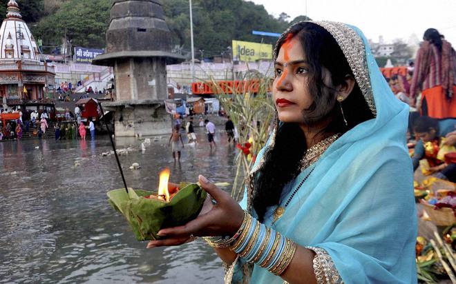 A woman offers prayers during Chhath Puja at Brahm Kund in Haridwar on November 17, 2015