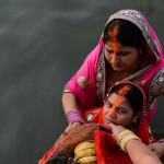 Hindu devotees hold offerings before prayers during the Chhat festival on the banks of the river Yamuna in New Delhi on November 17, 2015