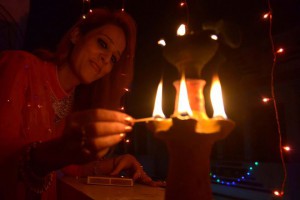 Woman lights an earthen lamp in Amritsar on November 10, 2015 on the eve of the festival of Diwali