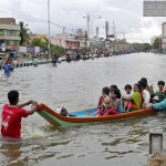 People ferried across a flooded road to safer paces in Chennai on December 2, 2015.