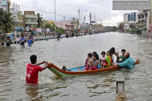 People ferried across a flooded road to safer paces in Chennai on December 2, 2015.