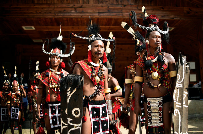 Tribal men dressed in traditional attire wait for their turn to perform a folk dance during the Hornbill Festival at Kisama village in the northeastern state of Nagaland on December 1, 2016.