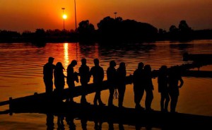 Visitors stand on a wall of the holy pond Braham Sarover for a pose as sun is setting in the backdrop in during ‘Gita Jayanti Mahotsava’ in Kurukshetra on December 21, 2015