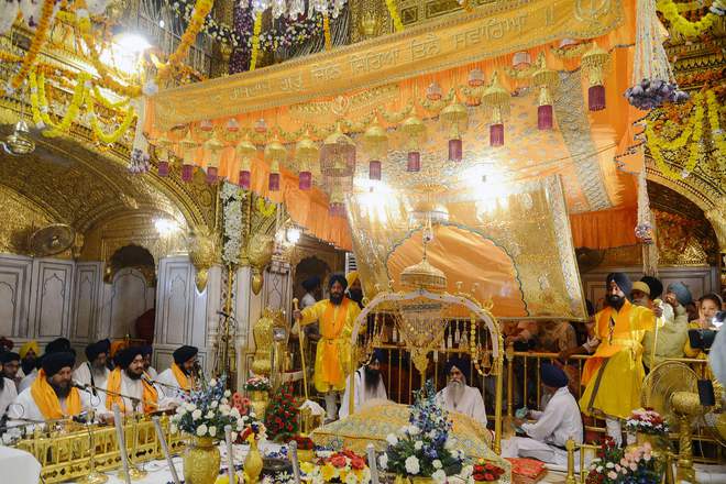 A Sikh priest sits behind the Sikh Holy Book during a Jalau ritual inside the Sikh Shrine Golden Temple in Amritsar on October 17, 2016.