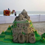 A boy enjoys camel ride on the back drop of a New Year sand sculpture created by sand artist Manas Sahoo on the eve of New Year at Puri beach