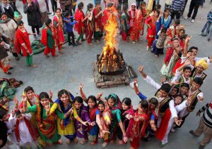 Girls in traditional attire dance around a bonfire as they celebrate Lohri festival in Jammu