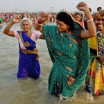 Hindu devotees dance as they take a holy bath and perform rituals at the Gangasagar Island some 150 kms south of Kolkata on January 14, 2016