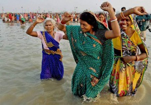 Hindu devotees dance as they take a holy bath and perform rituals at the Gangasagar Island some 150 kms south of Kolkata on January 14, 2016