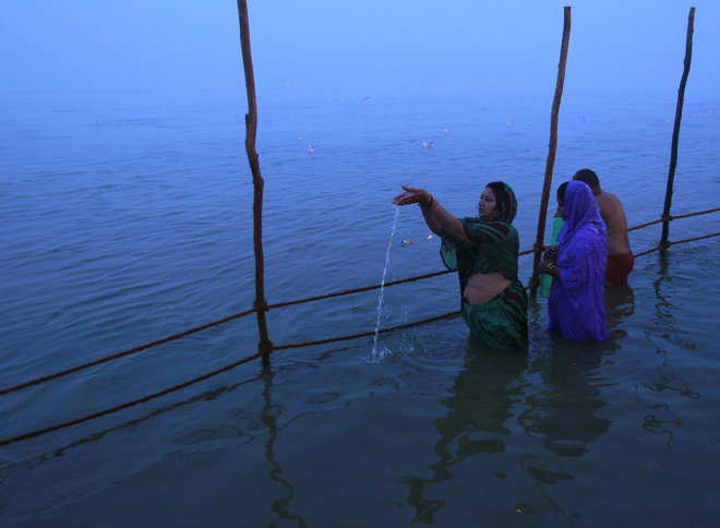 Hindu devotees offer prayers at Sangam the confluence of the Ganges Yamuna and Saraswati rivers on a foggy winter morning on the occasion of Makar Sankranti festival in Allahabad India on January 15, 2016