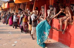 Hindu devotees seek blessings from Naga Sadhus at Gangasagar Island. Devotees and Monks gather in Gangasagar mela for holy dip on the occasion of Makar Sankranti