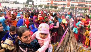 Mother with their daughters around a bonfire to celebrate Lohri in Karnal
