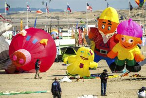 People fly kites of different shapes and colours during the 30th International Kite Festival in Berck-sur-Mer in northern France on April 12, 2016