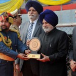 Punjab Vidhan Sabha speaker Charanjit Singh Atwal gives an award to a recipient during the Republic Day function at Guru Nanak Stadium in Ludhiana