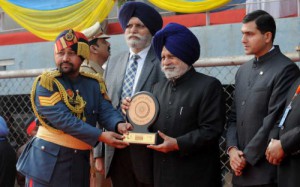 Punjab Vidhan Sabha speaker Charanjit Singh Atwal gives an award to a recipient during the Republic Day function at Guru Nanak Stadium in Ludhiana