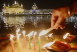 Sikh devotees light candles at the Golden Temple in Amritsar on October 17, 2016 during an event to mark the birth anniversary of the fourth Sikh Guru Ramdas.
