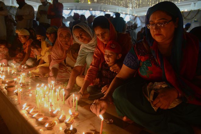 Sikh devotees light candles at the Golden Temple in Amritsar on October 17, 2016 during an event to mark the birth anniversary of the fourth Sikh Guru Ramdas.