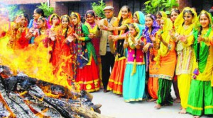 Students dressed in traditional clothes stand near a bonfire during Lohri celebrations at DAV Public School in Patiala
