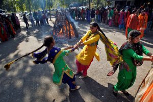 Students perform a traditional folk dance near a bonfire as they celebrate the Lohri festival, inside a college in Chandigarh
