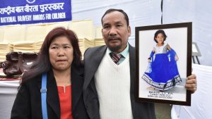 Tarh Peeju’s parents hold a picture of their daughter who won an award (Posthumously) for saving two children from drowning in a river, losing her life because of strong undercurrents