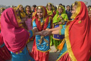 Young girls wear traditional Punjabi dress as they perform the giddha during celebrations on the eve of the Lohri festival in Amritsar