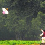 Boy flies a kite in a field in Ludhiana