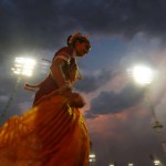 A participant runs towards her group before their performance during the World Culture Festival on the banks of the river Yamuna in New Delhi