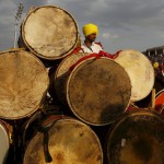 A participant stands next to drums as he watches others performing dance during the World Culture Festival on the banks of the river Yamuna in New Delhi on March 12 2016
