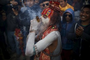 A Hindu holy man, or sadhu, smeared with ashes smokes marijuana in a chillum during the Shivaratri festival on the premises of Pashupatinath Temple in Kathmandu, Nepal, March 7, 2016. Hindu holy men from Nepal and India come to this temple to take part in the Maha Shivaratri festival. Celebrated by Hindu devotees all over the world, Shivaratri is dedicated to Lord Shiva, and holy men mark the occasion by praying, smoking marijuana or smearing their bodies with ashes.