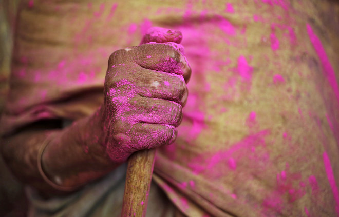 A widow holds a stick during Holi celebrations at a temple in Vrindavan, Uttar Pradesh