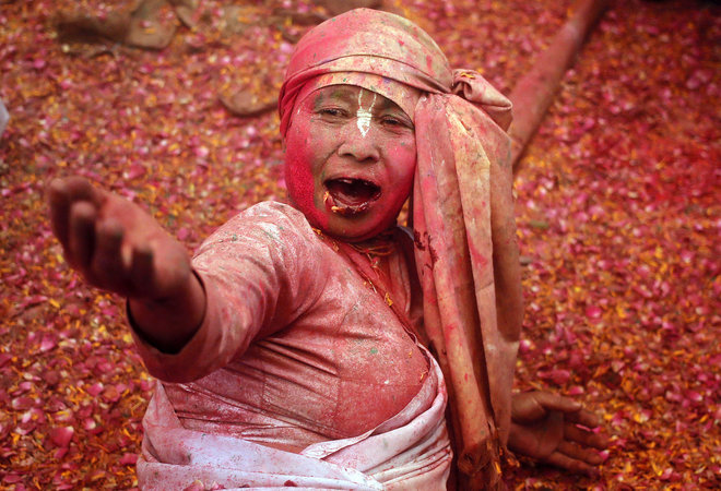 A widow sings religious songs during Holi celebrations at a temple in Vrindavan, Uttar Pradesh