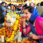 A woman devotee says her wish in the ears of Nandi Maharaj in Panchkula