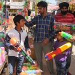 People purchase water guns for their children at a market in Amritsar