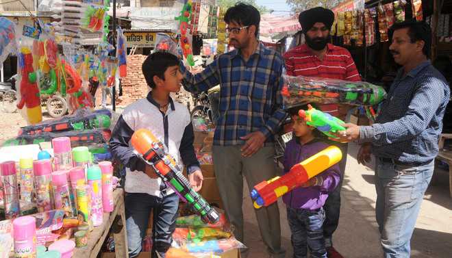 People purchase water guns for their children at a market in Amritsar