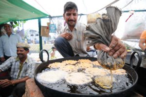 A roadside vendor fries a jalebis, a sweet dish, at a fair to mark Baisakhi in Jammu