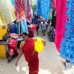 An Indian woman carries a pot containing drinking water at a residential area in Chennai