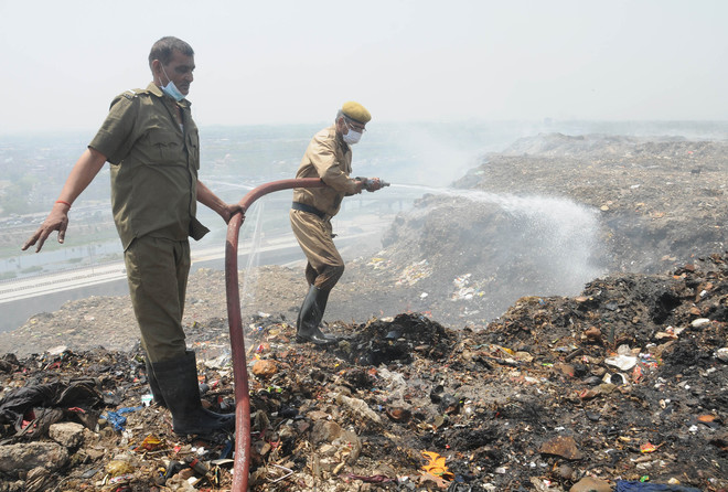 Delhi’s firemen douse a fire at a dump yard in northwest Delhi on World Earth Day on April 22, 2016.