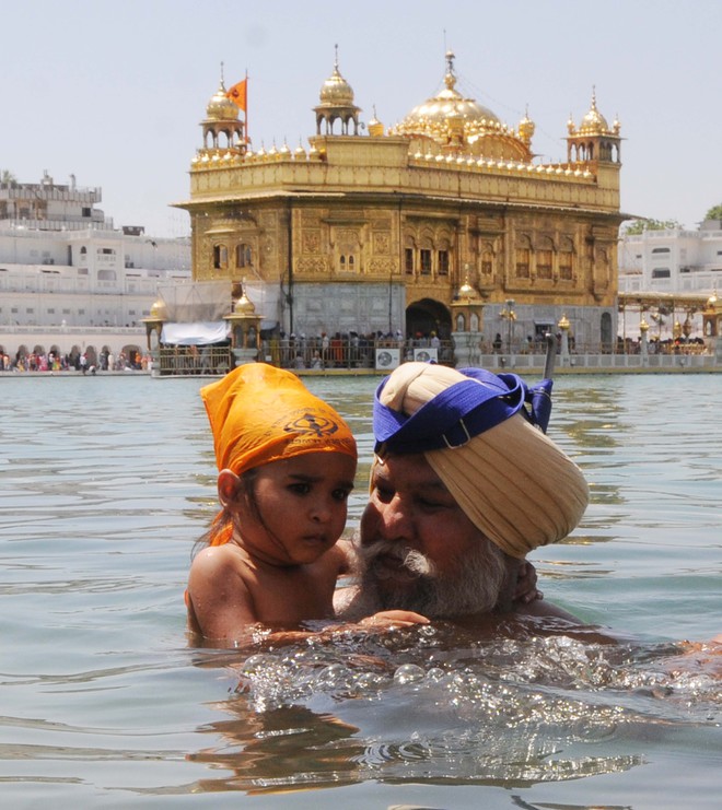 Devotees take a dip in the holy sarovar at the Golden Temple in Amritsar to mark Baisakhi on April 13, 2016