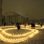 People attend a candle light vigil at the Vilnius Cathedral as it stands unlit during Earth Hour in Vilnius, Lithuania, on March 19, 2016