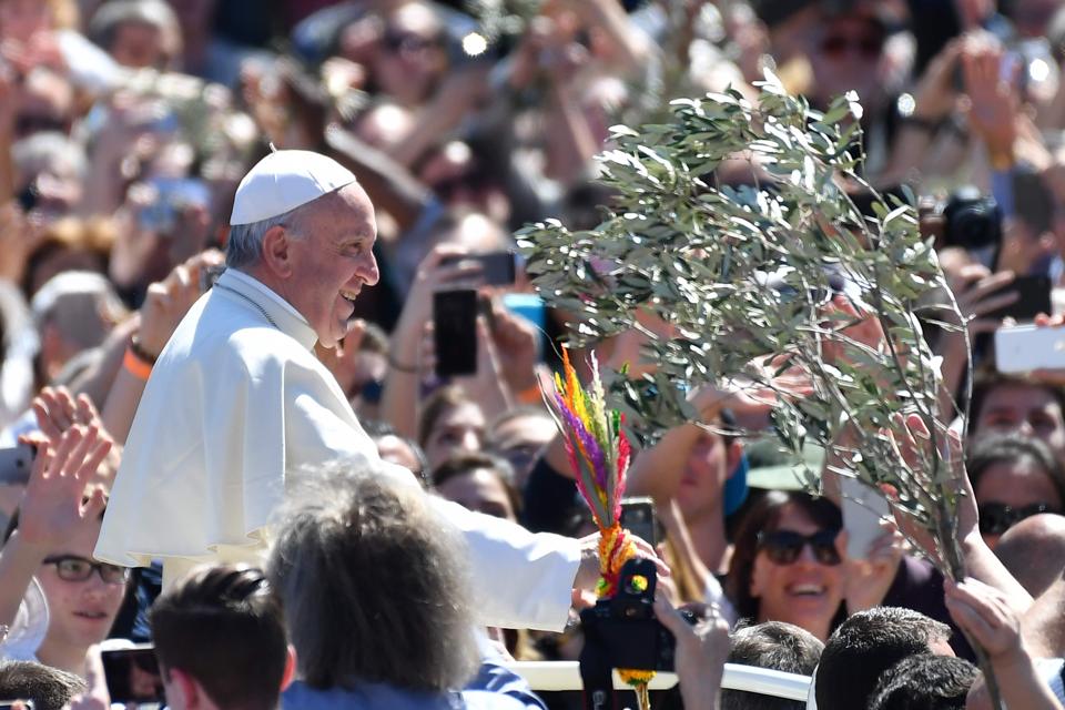 Pope Francis greets the crowd at the end of the Palm Sunday mass