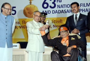 President Pranab Mukherjee being received a Shain Baba statue from Dadasaheb Phalke Award winner Manoj Kumar at the 63rd National Film Awards 2015 function at Vigyan Bhawan in New Delhi on Tuesday. I & B Minister Arun Jaitley and Minister of State Rajyavardhan Singh Rathore are also seen.