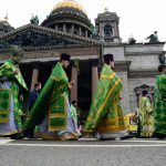 Russian Orthodox priests carry palm branches during the Palm Sunday procession outside the Saint Isaac's Cathedral in Saint Petersburg