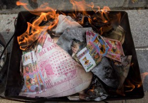 So called 'spirit money' burns next to a grave as an offering during the annual Qingming festival, or Tomb Sweeping Day, at a public cemetery in Shanghai on April 4, 2016