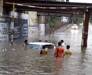 People help a car stuck in floodwater in Moga, Punjab, on June 14. 2016.