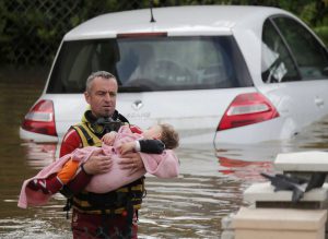 A French firefighter evacuates a baby from a flooded area after heavy rain falls in Chalette-sur-Loing, near Orleans, France, June 1.