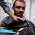 A Syrian man carries the body of his nephew following a reported airstrike on September 23, 2016, on the al-Muasalat area in the northern Syrian city of Aleppo.