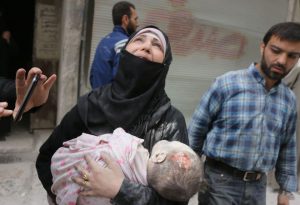 A Syrian woman carries the body of her infant after he was retrieved from under the rubble of a building following a reported airstrike on September 23, 2016, on the al-Muasalat area in the northern Syrian city of Aleppo.