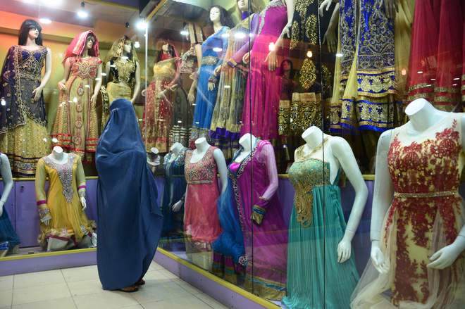 A burqa-clad shopper looks at mannequins in Herat on September 8 on the eve of Eid al-Adha celebrations.